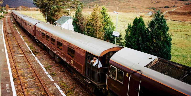 The Royal Scotsman's claret carriages at a Highland station